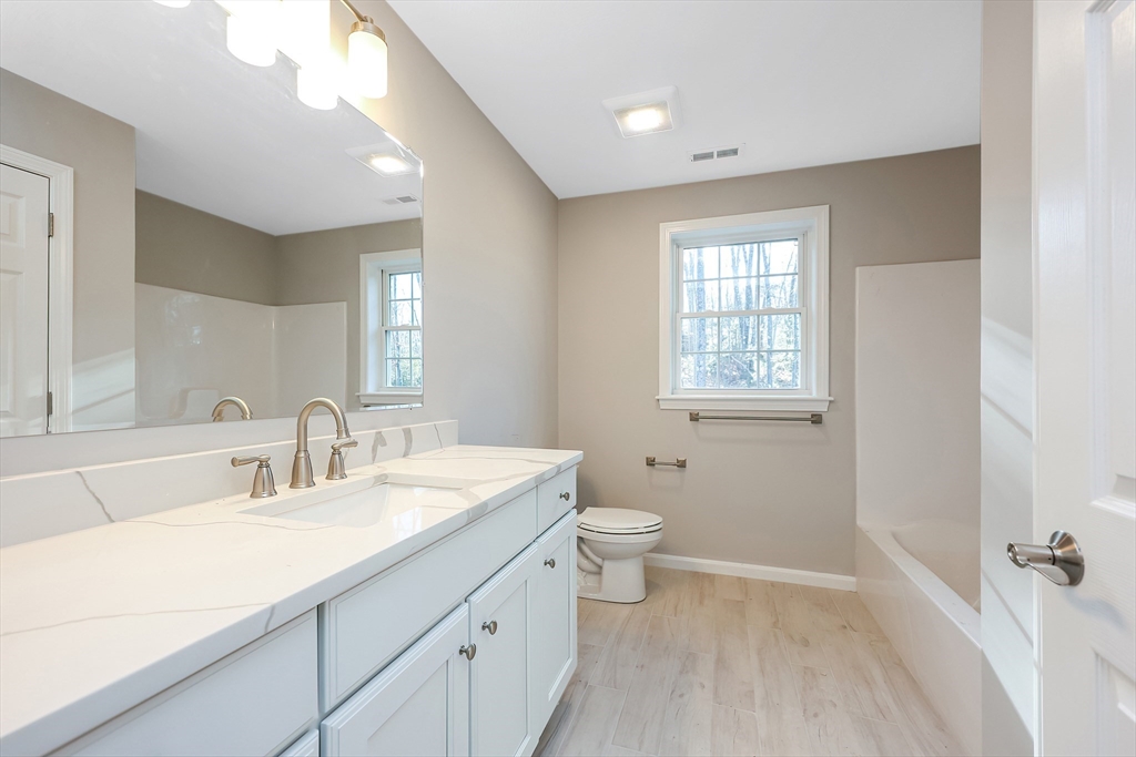 19 Oriole Drive Groton, MA 01450 - Photo 23 of 33 a bathroom with a sink a toilet a tub and a mirror