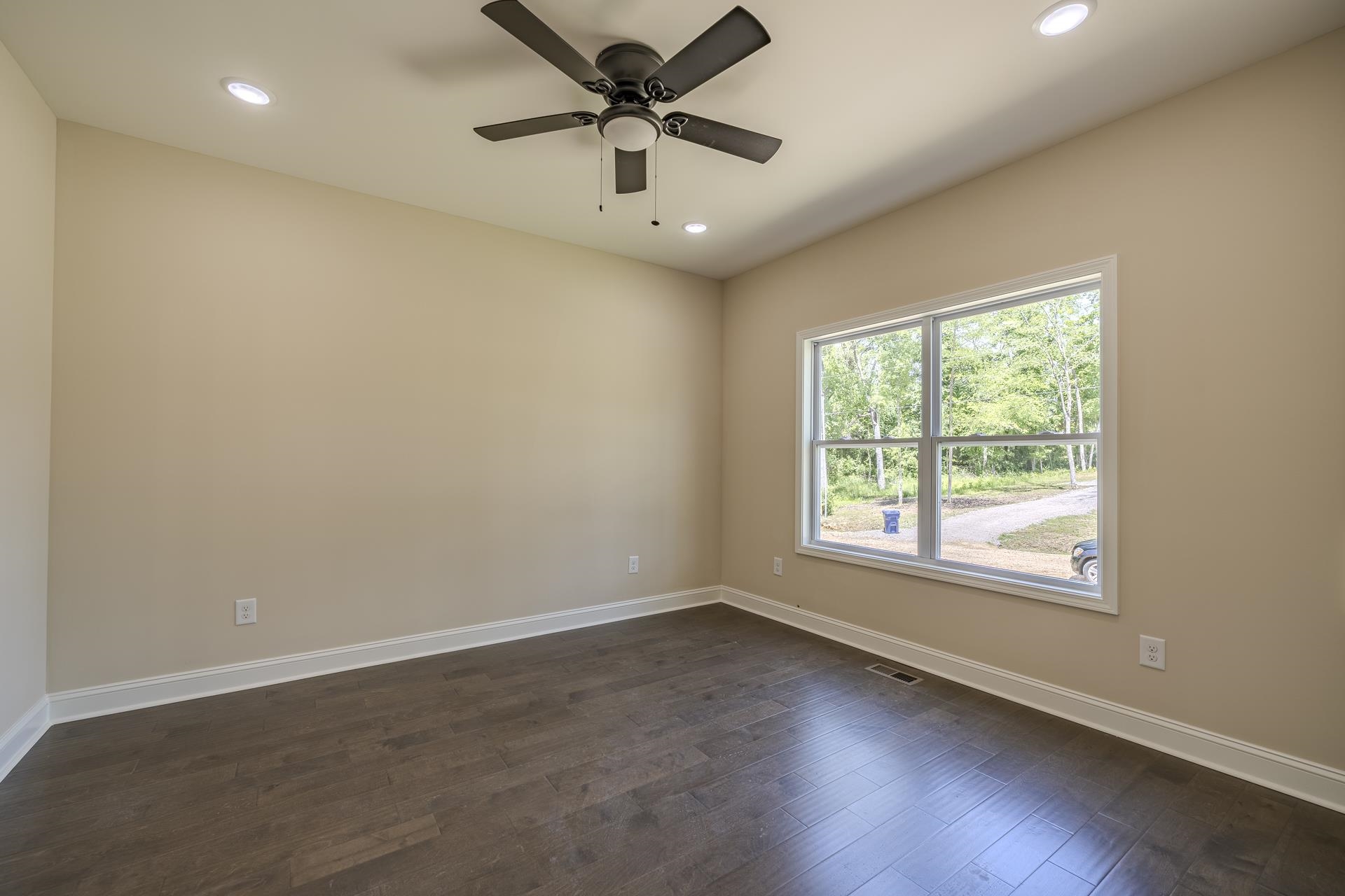 50 Fox Trot Road Adamsville, TN 38310 - Photo 12 of 40 en empty room with wooden floor and ceiling fan