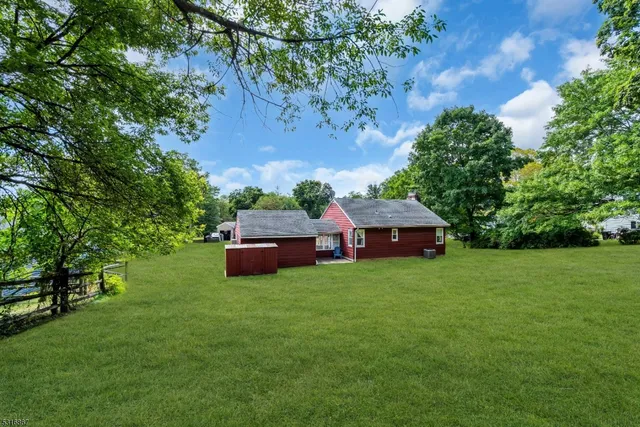 a view of house with a big yard and potted plants
