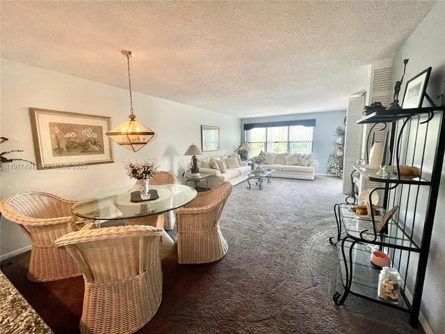 a dining room with furniture and a floor to ceiling window