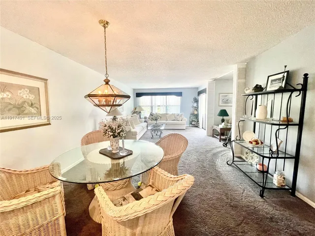 a dining room with furniture and a floor to ceiling window