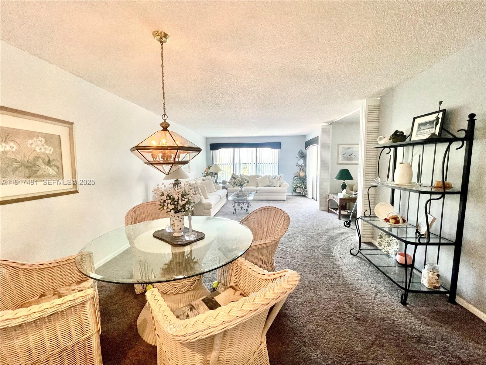 2309 South Cypress Bend Drive, Unit 311 Pompano Beach, FL 33069 - Photo 14 of 51 a dining room with furniture and a floor to ceiling window