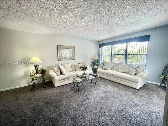 a living room with furniture and a large window with outer view