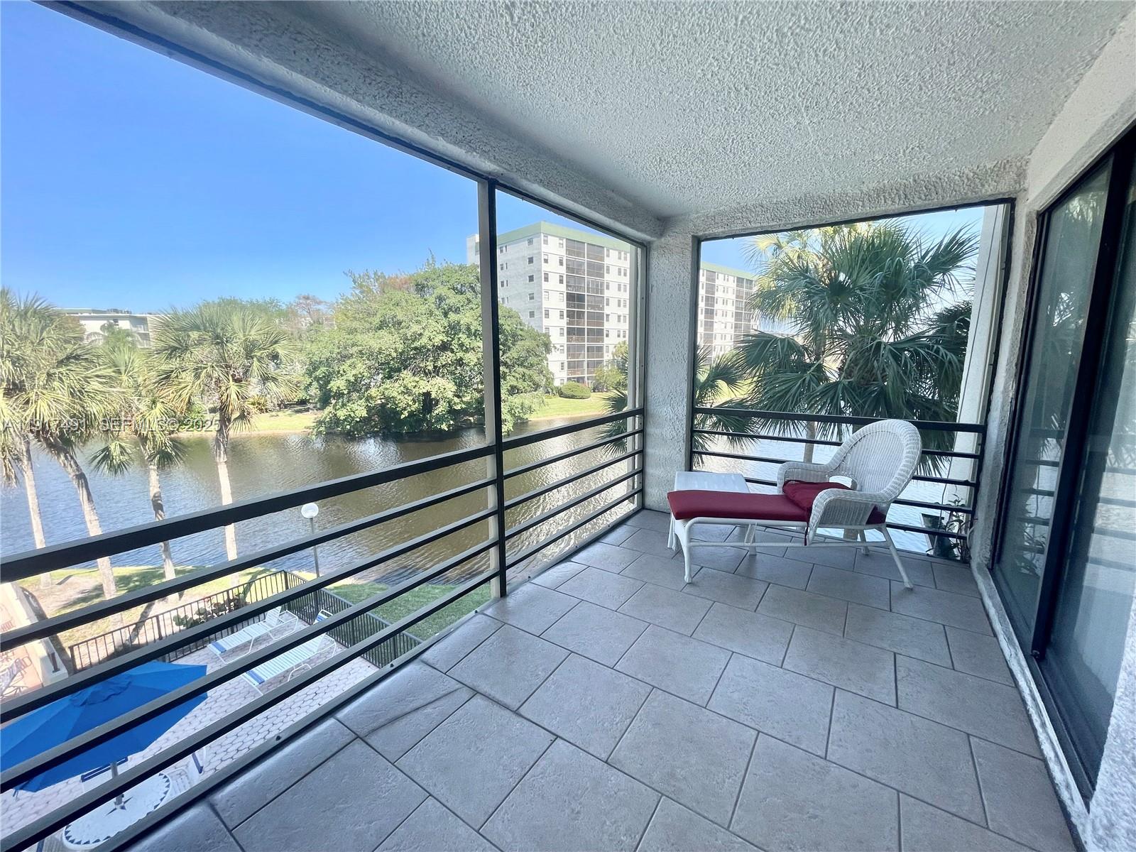 2309 South Cypress Bend Drive, Unit 311 Pompano Beach, FL 33069 - Photo 21 of 51 a living room with furniture and a floor to ceiling window