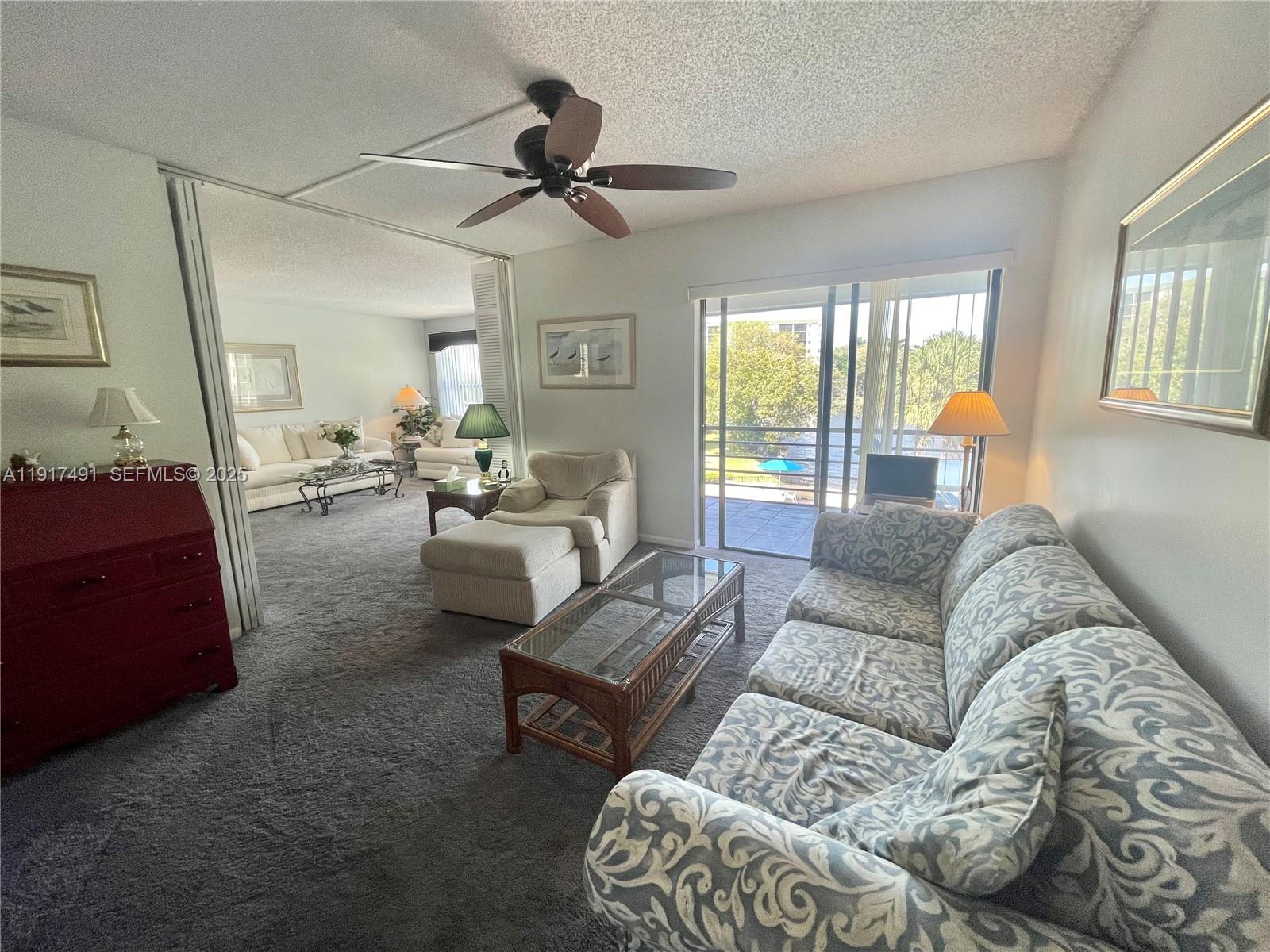 2309 South Cypress Bend Drive, Unit 311 Pompano Beach, FL 33069 - Photo 27 of 51 a living room with furniture and a window