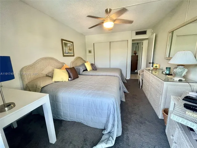 a spacious bedroom with two beds and a chandelier