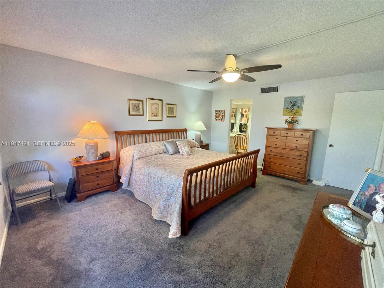 2309 South Cypress Bend Drive, Unit 311 Pompano Beach, FL 33069 - Photo 37 of 51 a bedroom with a bed and a chandelier