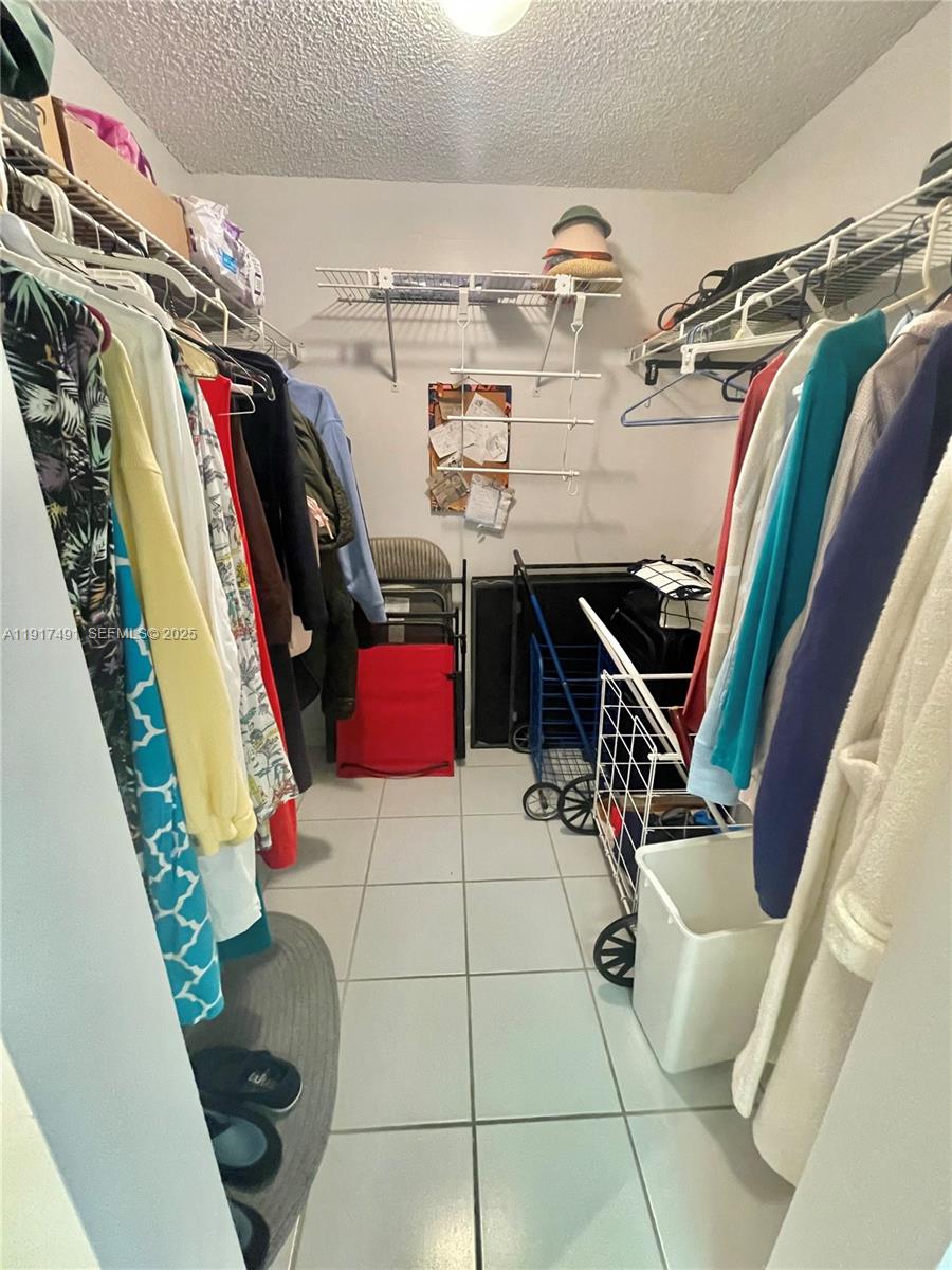 2309 South Cypress Bend Drive, Unit 311 Pompano Beach, FL 33069 - Photo 39 of 51 a view of walk in closet with clothes and shoes