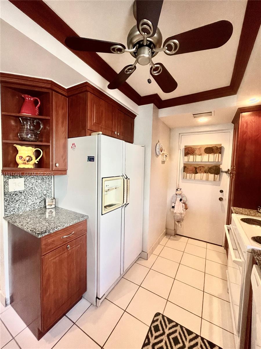 2309 South Cypress Bend Drive, Unit 311 Pompano Beach, FL 33069 - Photo 9 of 51 a bedroom with a bed and a chandelier