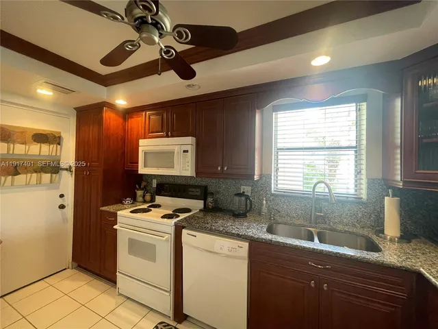 a kitchen that has a sink stainless steel appliances cabinets and a window