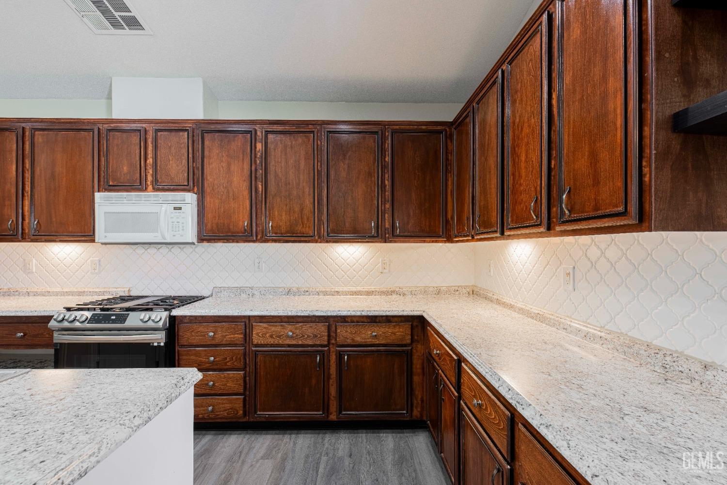 Undisclosed Address Bakersfield, CA 93312 - Photo 12 of 44 a kitchen with a sink a stove and cabinets