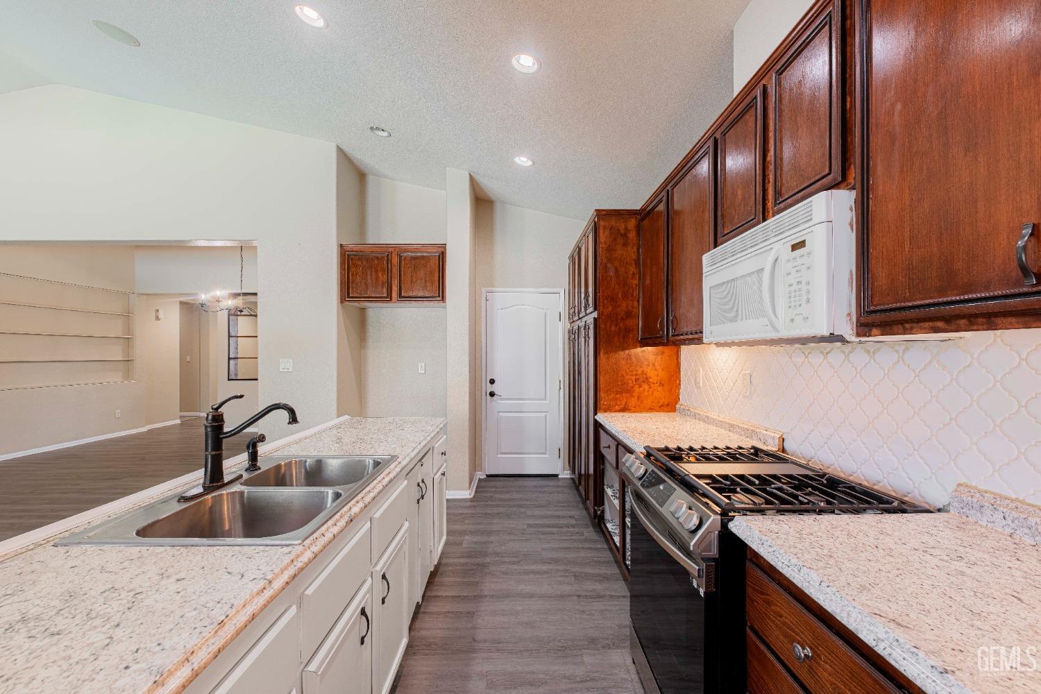 Undisclosed Address Bakersfield, CA 93312 - Photo 13 of 44 a kitchen with stainless steel appliances granite countertop a sink and a stove