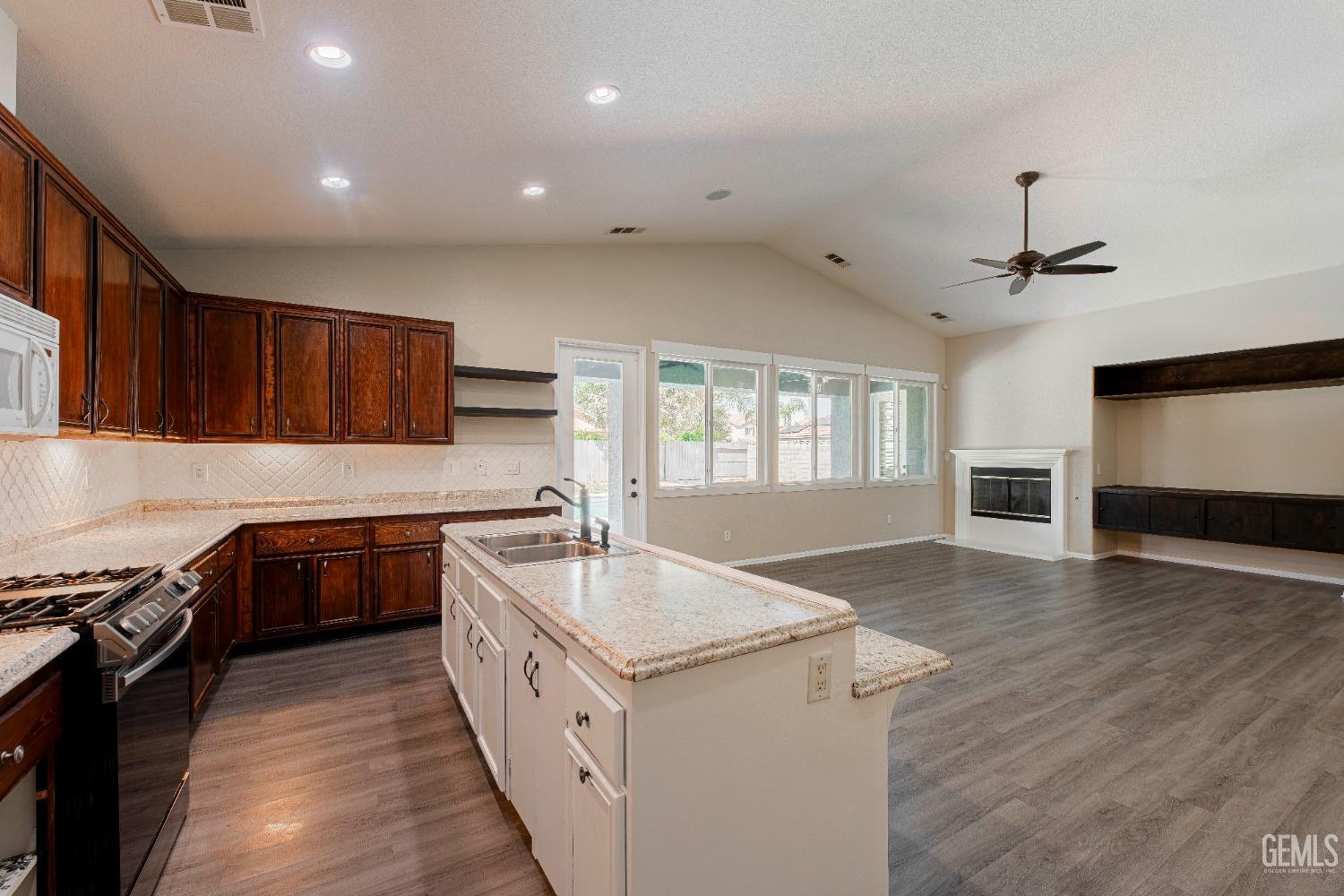 Undisclosed Address Bakersfield, CA 93312 - Photo 14 of 44 a large white kitchen with wooden floor and a sink