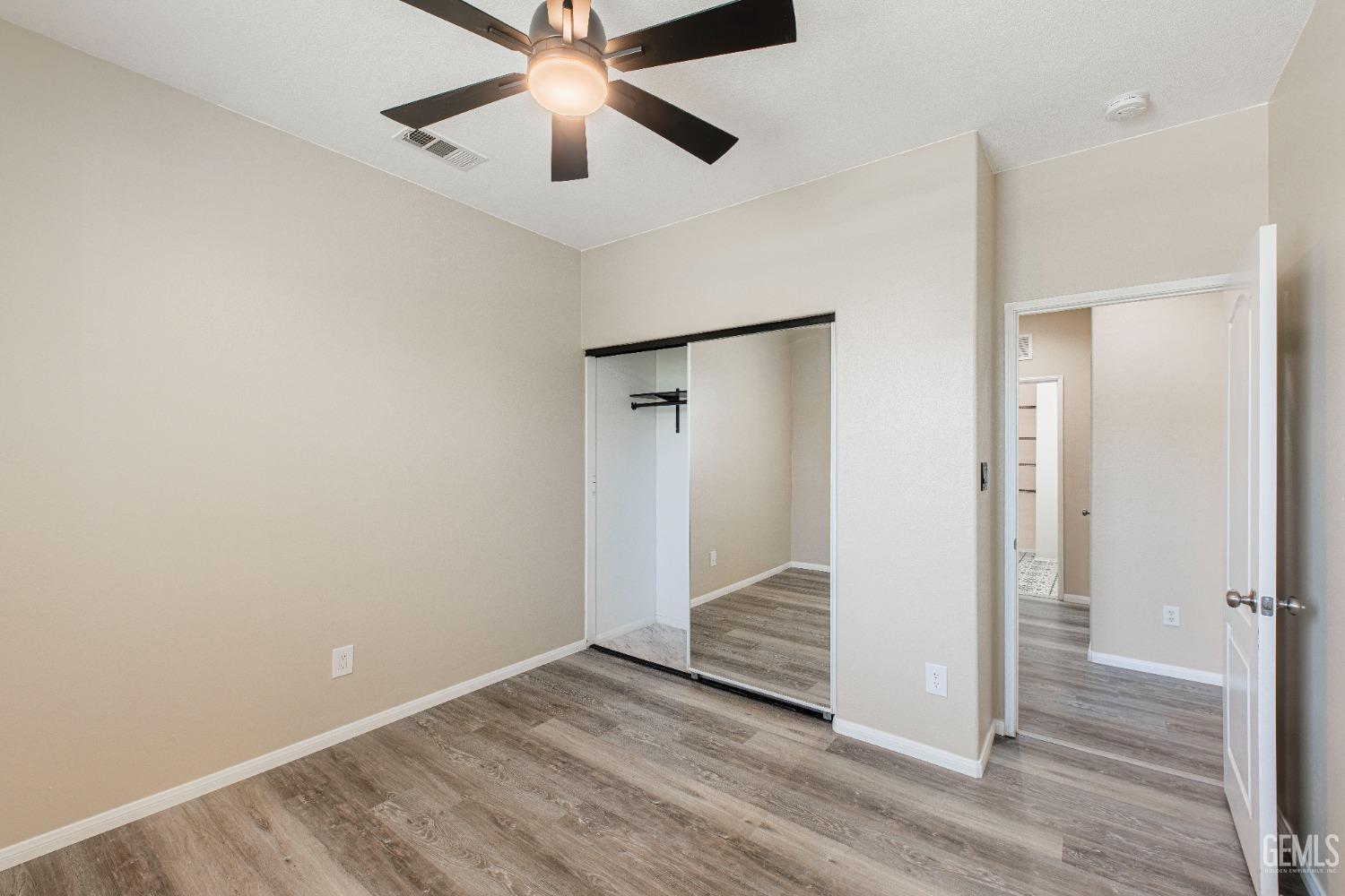 Undisclosed Address Bakersfield, CA 93312 - Photo 23 of 44 an empty room with wooden floor and door
