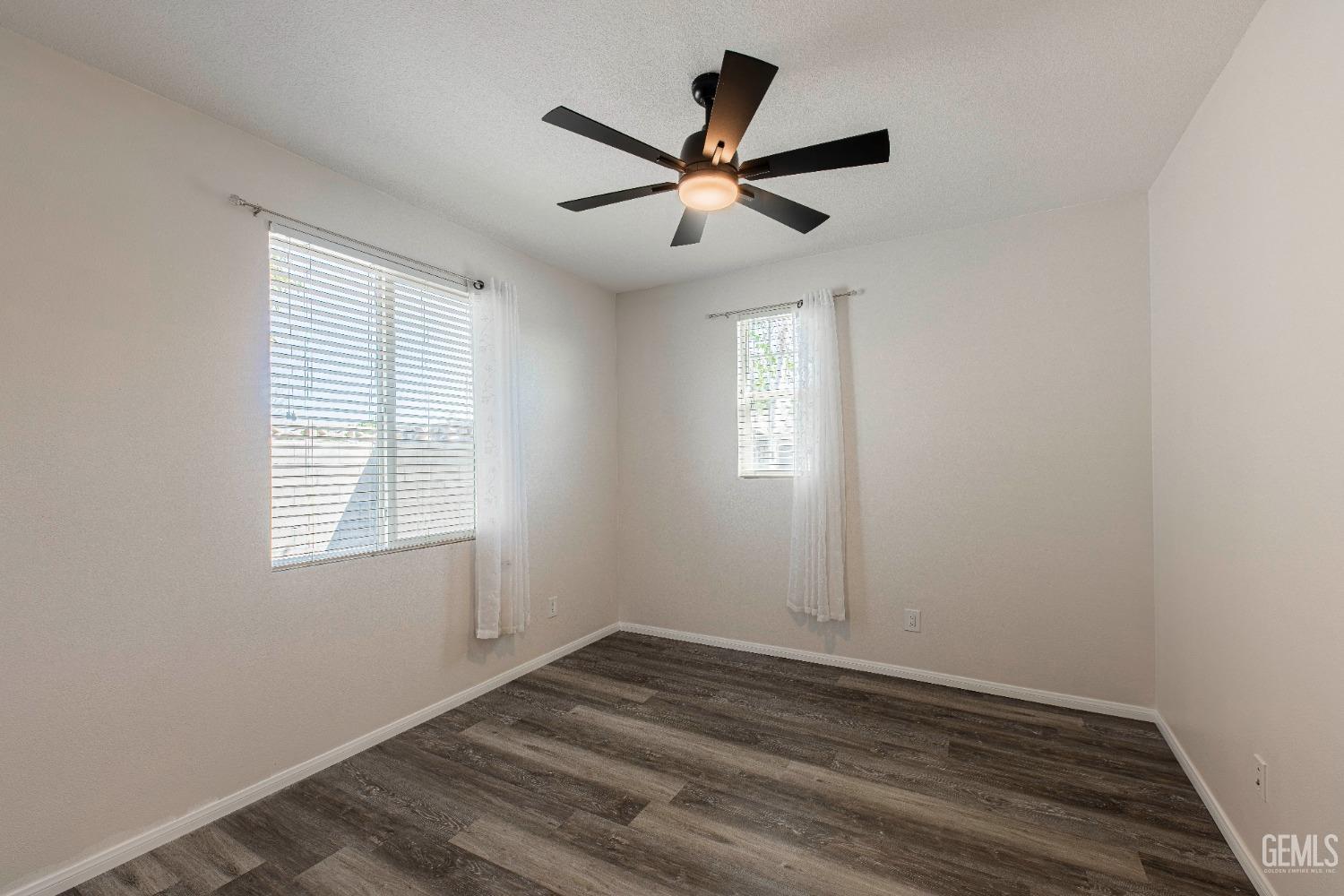 Undisclosed Address Bakersfield, CA 93312 - Photo 26 of 44 a view of empty room with wooden floor and fan