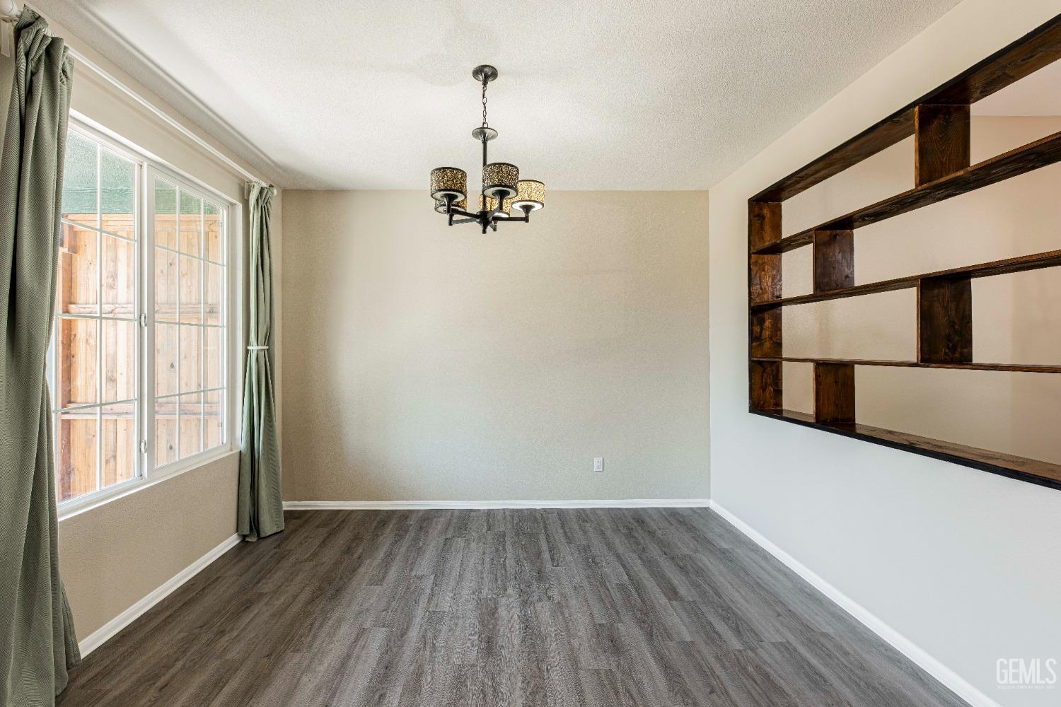 Undisclosed Address Bakersfield, CA 93312 - Photo 3 of 44 a view of empty room with a window and wooden floor