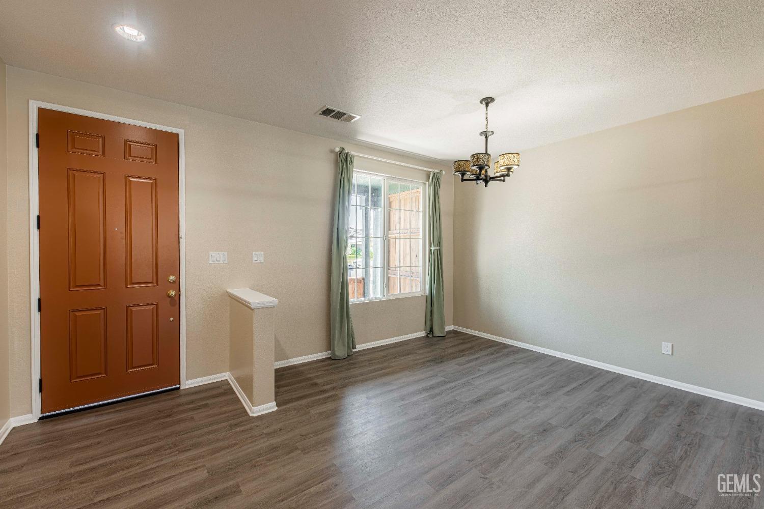 Undisclosed Address Bakersfield, CA 93312 - Photo 4 of 44 an empty room with wooden floor cabinet and windows