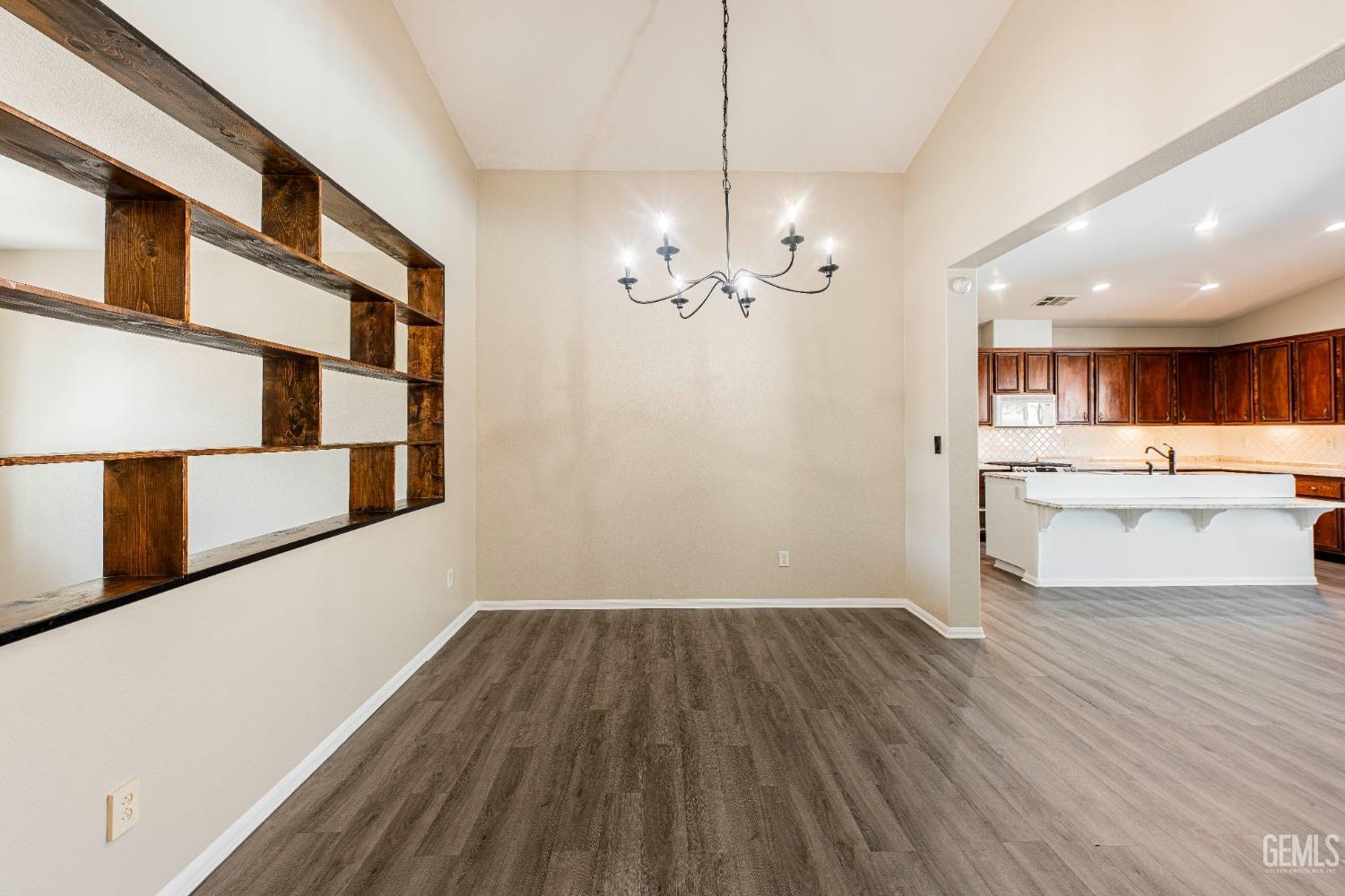 Undisclosed Address Bakersfield, CA 93312 - Photo 6 of 44 a view of a kitchen with a sink dishwasher a kitchen island a stove and a wooden floors