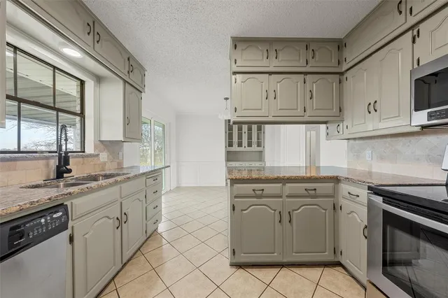 a kitchen with white cabinets and appliances