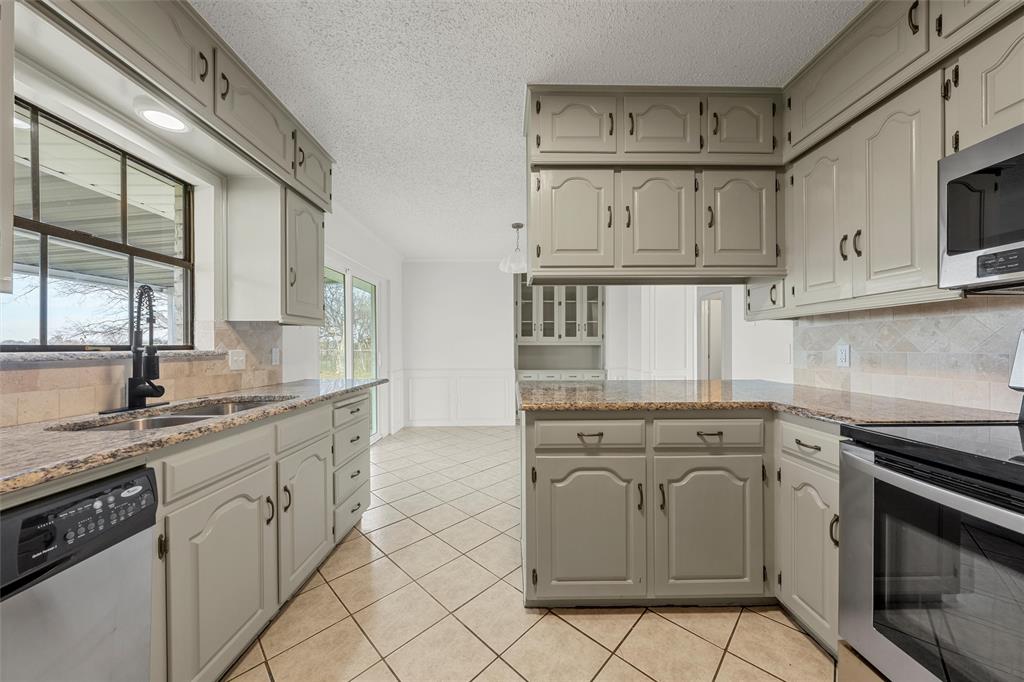 608 South Colorado Street Whitney, TX 76692 - Photo 12 of 27 a kitchen with white cabinets and appliances