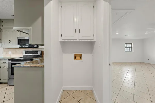 a kitchen with stainless steel appliances granite countertop a refrigerator a stove and white cabinets