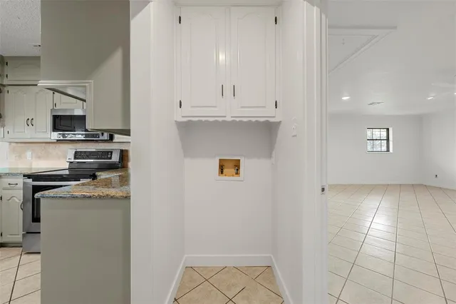 a kitchen with stainless steel appliances granite countertop a refrigerator a stove and white cabinets