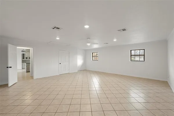 an empty room with white walls and windows