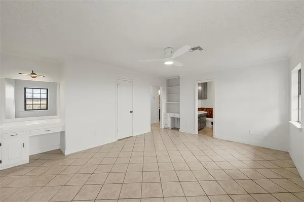 a view of an empty room with window and cabinet