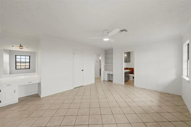 a view of an empty room with window and cabinet