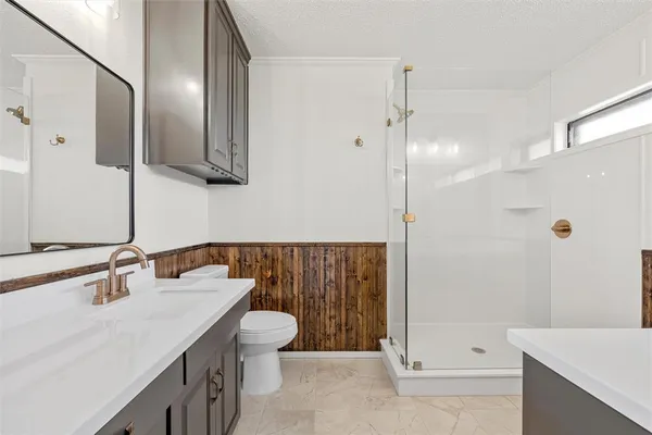 a bathroom with a sink a toilet and shower