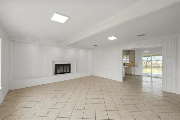 an empty room with windows and fireplace