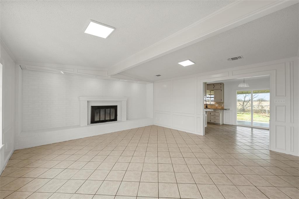 608 South Colorado Street Whitney, TX 76692 - Photo 4 of 26 an empty room with windows and fireplace