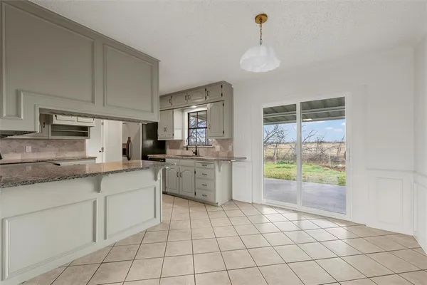 a kitchen with a stove a sink dishwasher a refrigerator and white cabinets with wooden floor