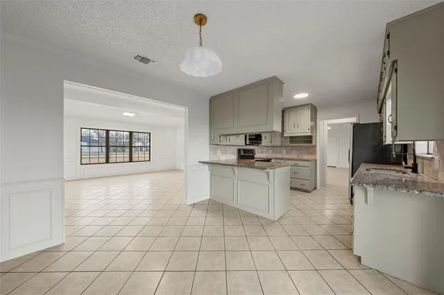a kitchen with white cabinets and appliances