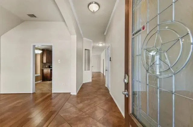 a view of a hallway with wooden floor and entryway