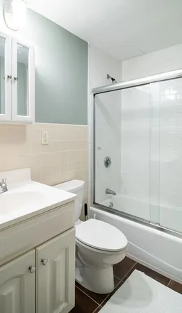 a bathroom with a sink a toilet and shower
