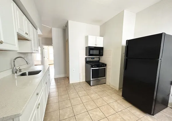 a kitchen with stainless steel appliances a refrigerator sink and microwave