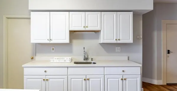 a kitchen with white cabinets and a sink