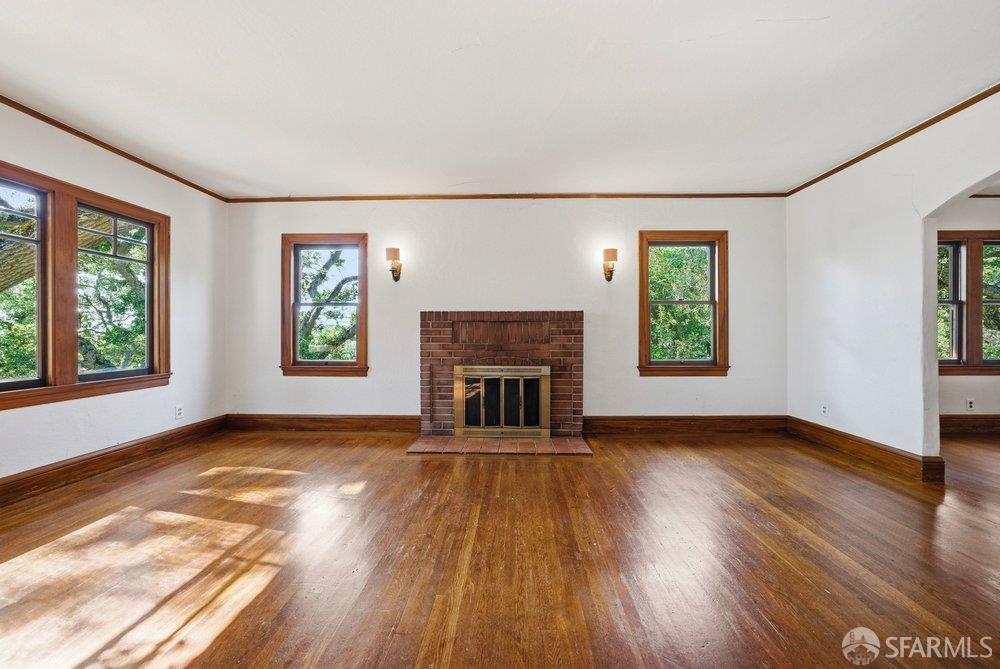 451 Vincente Avenue Berkeley, CA 94707 - Photo 11 of 66 an empty room with windows a fireplace and wooden floor