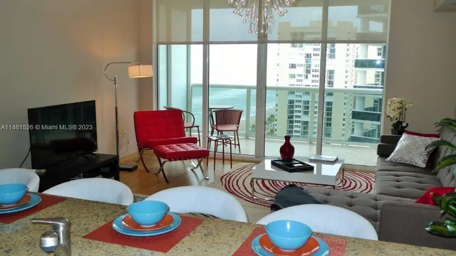 a living room with furniture and a floor to ceiling window