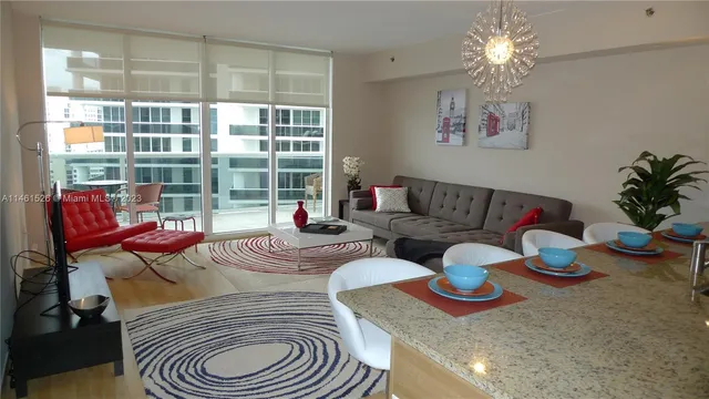 a living room with furniture and a floor to ceiling window
