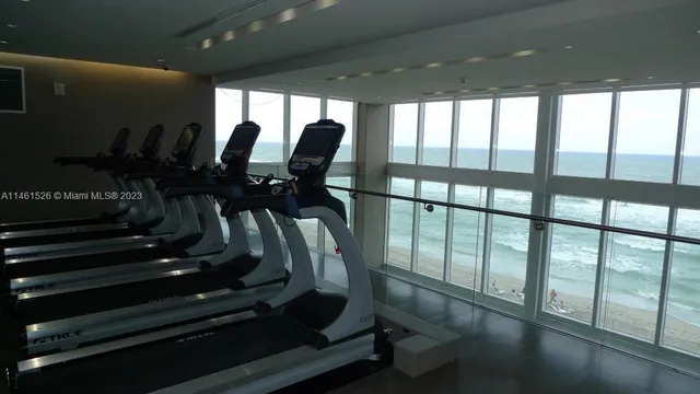 a room with gym equipment and large mirror