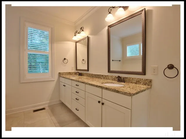 a bathroom with a granite countertop sink a mirror and a window