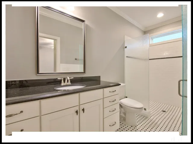 a bathroom with a granite countertop sink a toilet and a mirror