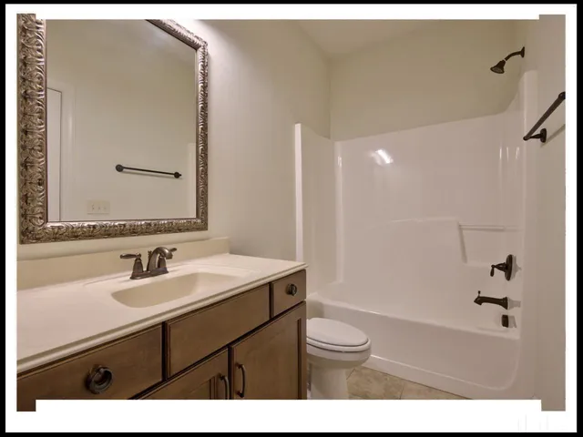 a bathroom with a sink a toilet a mirror and shower