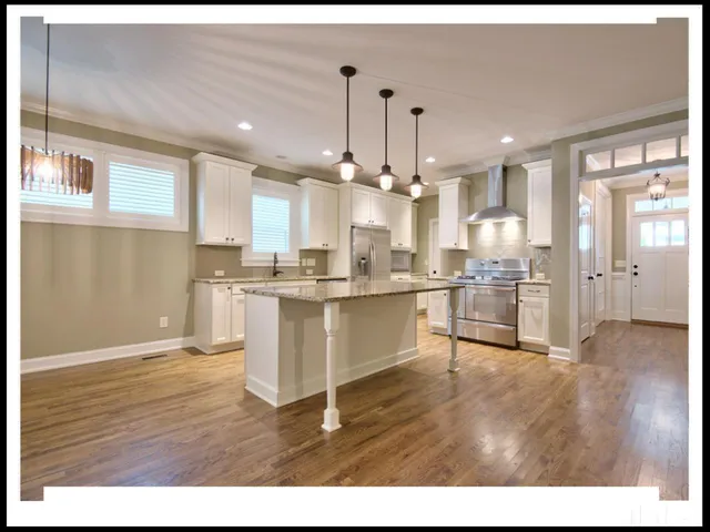 a view of a kitchen with kitchen island a sink stainless steel appliances and cabinets