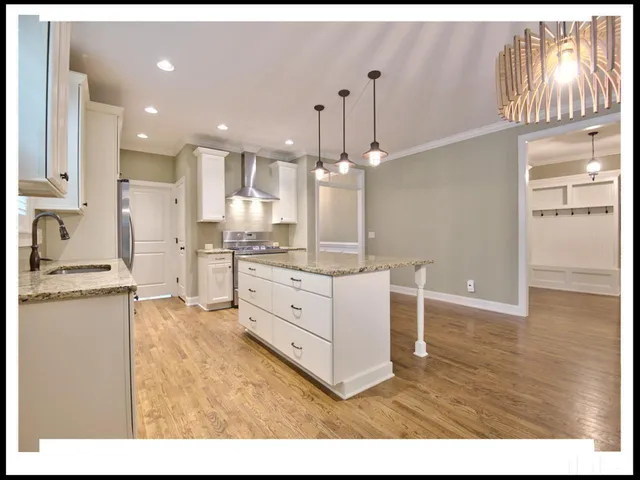 a kitchen with granite countertop a sink cabinets and stainless steel appliances