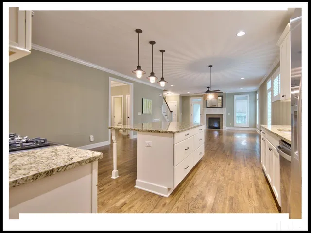 a open kitchen with a sink stove and white cabinets