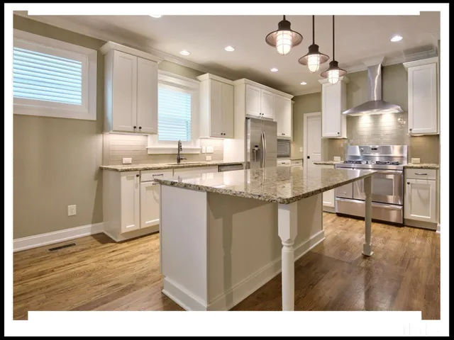 a kitchen with stainless steel appliances granite countertop a sink a stove and a refrigerator