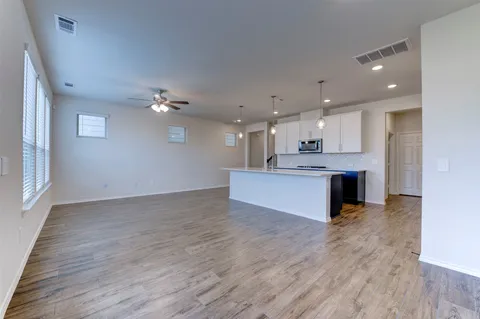 a large kitchen with a lot of counter space and a ceiling fan